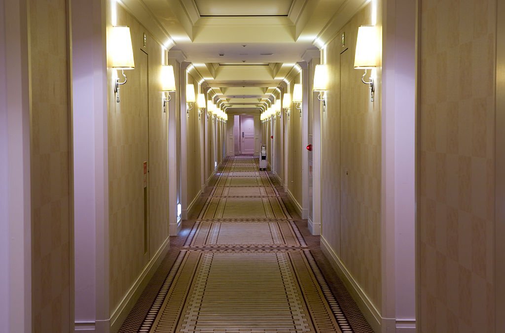 janitor with broom cleaning office corridor